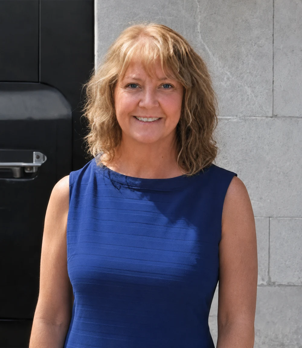 Terri Crawford, your travel advisor, smiling in a blue dress