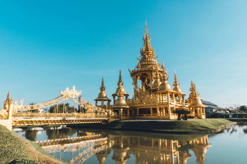 Ornate golden architecture beside the water in Thailand